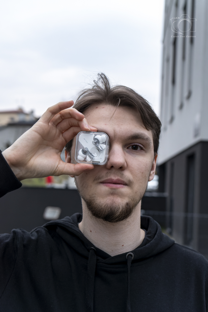 Designerskie słuchawki bezprzewodowe Nothing Ear 2 w rękach modela - fotografia lifestyle Mielec